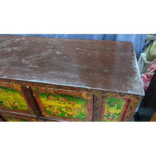 77 - A 19th century Tibetan cabinet, polychrome painted with panels depicting various deities in landscap... 