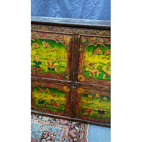 77 - A 19th century Tibetan cabinet, polychrome painted with panels depicting various deities in landscap... 