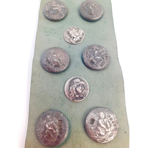 34 - A display of Circa 1900 French and English silver buttons, 17 in total, mounted on a green leather s... 