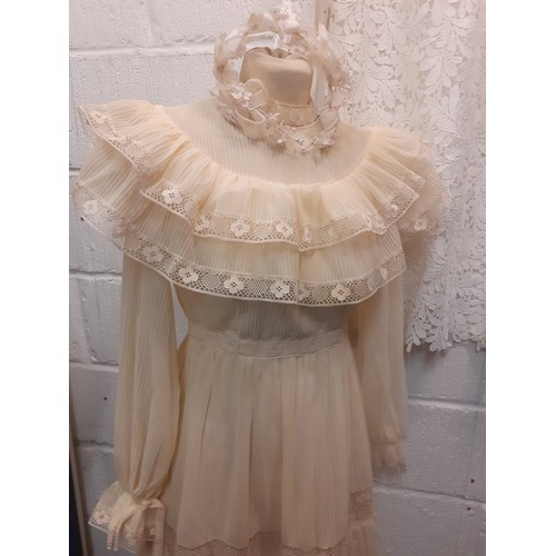 99 - A 1970's cream wedding dress UK10 with tiered skirt and lace insertions, together with a white tiara... 