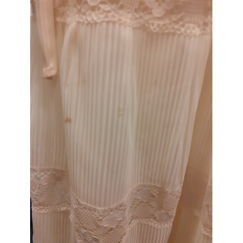 99 - A 1970's cream wedding dress UK10 with tiered skirt and lace insertions, together with a white tiara... 