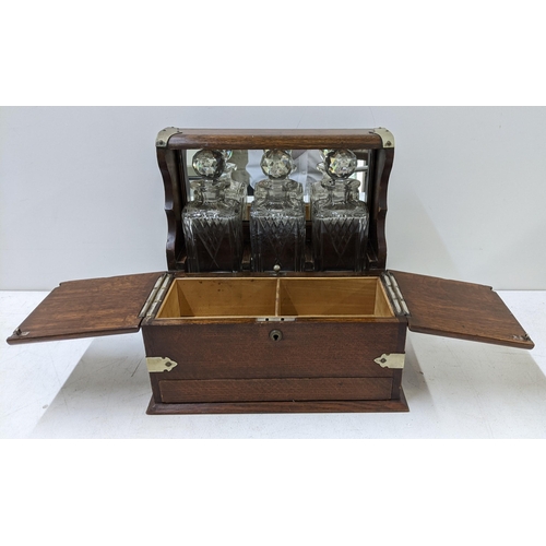 108 - An early 20th century oak and silver plate tantalus with two compartments without key and a secret d... 