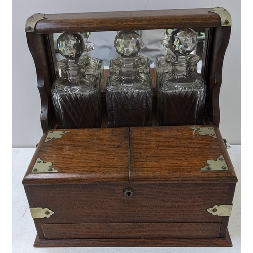 108 - An early 20th century oak and silver plate tantalus with two compartments without key and a secret d... 