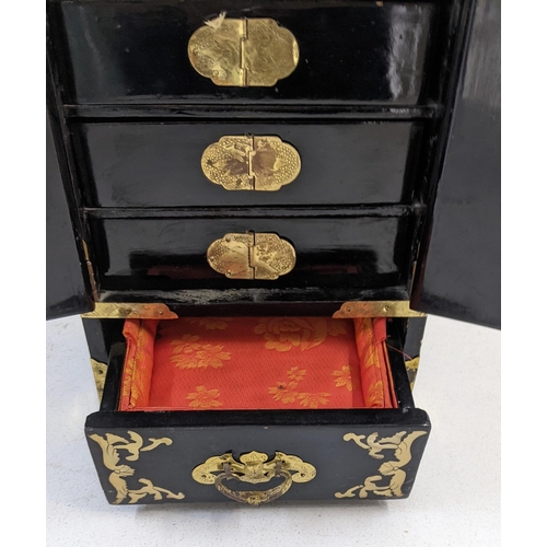 89 - An oriental, black lacquered jewellery cabinet with hinged doors and five compartments, A/F
Location... 