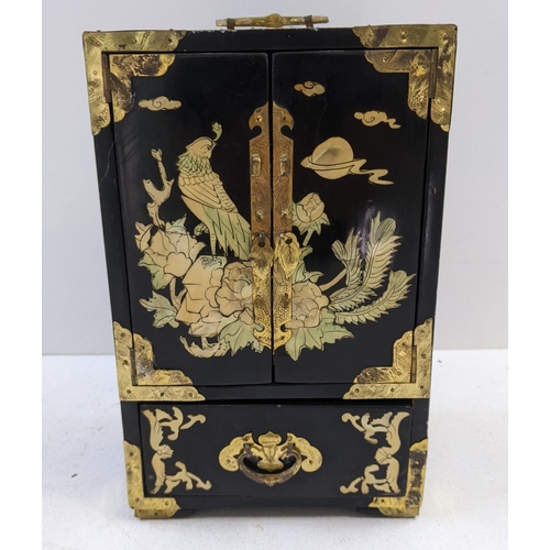 89 - An oriental, black lacquered jewellery cabinet with hinged doors and five compartments, A/F
Location... 