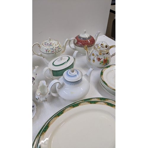 99 - A collection of dinner and tea ware to include a crescent ivory green and white part dinner service,... 