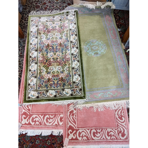 144 - Four rugs, a pair of pink examples with a scrolled border 137cm x 70cm, and two Chinese rugs, one wi... 