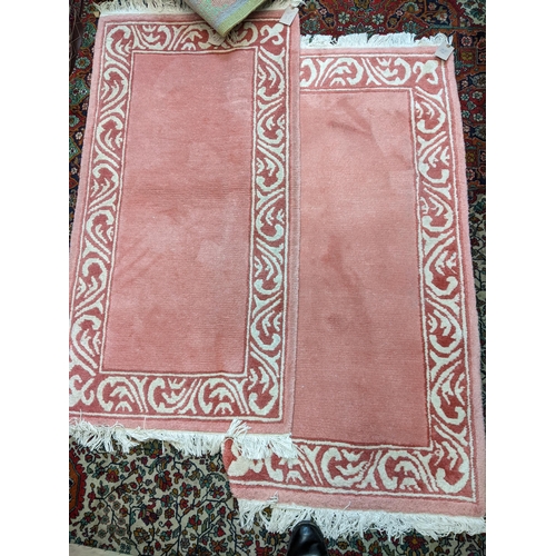 144 - Four rugs, a pair of pink examples with a scrolled border 137cm x 70cm, and two Chinese rugs, one wi... 