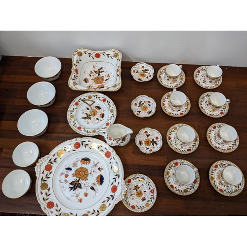 23 - A Royal Crown Derby tea service decorated in the Imari pattern to include cups and saucers, bowls, f... 