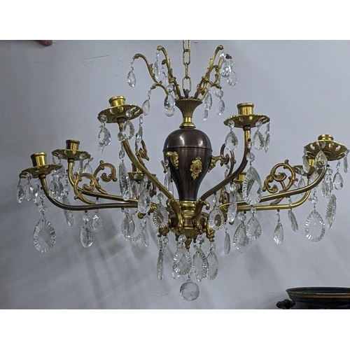 440 - A gilt metal eight-branch chandelier having scroll mounts, baluster columns and faceted cut glass dr... 