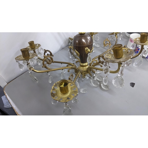 440 - A gilt metal eight-branch chandelier having scroll mounts, baluster columns and faceted cut glass dr... 