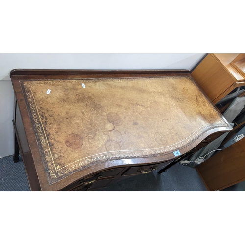 459 - Circa 1900, a mahogany serpentine fronted writing desk having a leather top and five drawers Locatio... 