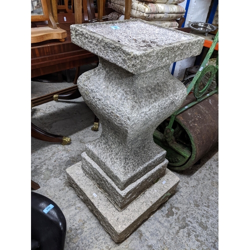 487 - A granite two piece pedestal garden bird table, the square table on a shouldered inverted baluster c... 