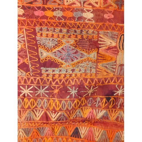 115 - A mid 20th Century embroidered Kilim wedding blanket having a terracotta ground with an orange, blue... 