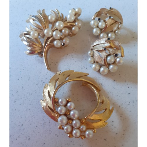 122 - A vintage  Trifari gold tone and pearl brooch and matching clip-on earrings together with 2 other br... 