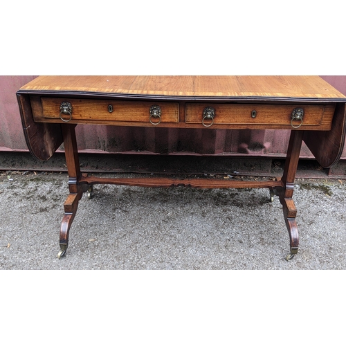 498 - A Regency mahogany sofa table, having a crossbanded rectangular top and two fall flaps, two frieze d... 