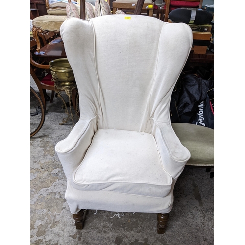 457 - An early to mid 20th century oak and upholstered wing back chair, floral fabric with cream over cove... 