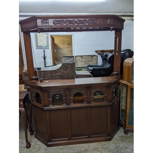 459 - An oak carved bar surround, the panelled base with five arched windows above, each having amber tint... 