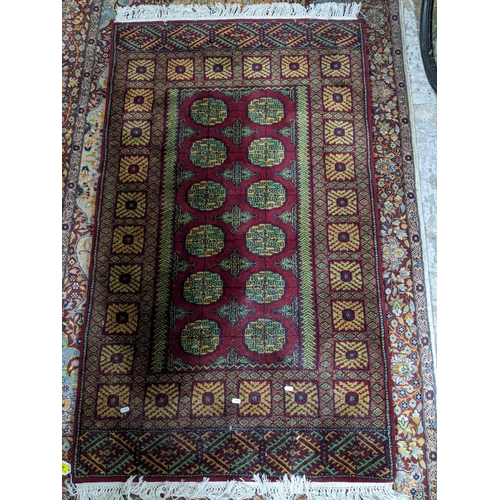 462 - An Indian handwoven red ground carpet, geometric devices and tasselled ends 170cm x 95cm, along with... 