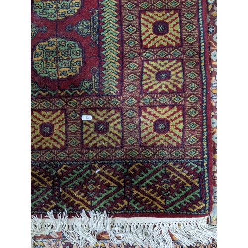 462 - An Indian handwoven red ground carpet, geometric devices and tasselled ends 170cm x 95cm, along with... 