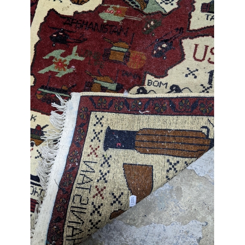 462 - An Indian handwoven red ground carpet, geometric devices and tasselled ends 170cm x 95cm, along with... 