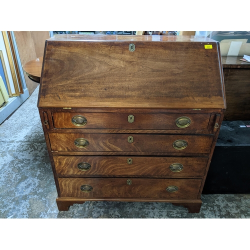 469 - A Georgian mahogany bureau, fall flap with pigeonhole and drawer interior, over a short drawer and t... 