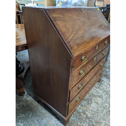 469 - A Georgian mahogany bureau, fall flap with pigeonhole and drawer interior, over a short drawer and t... 