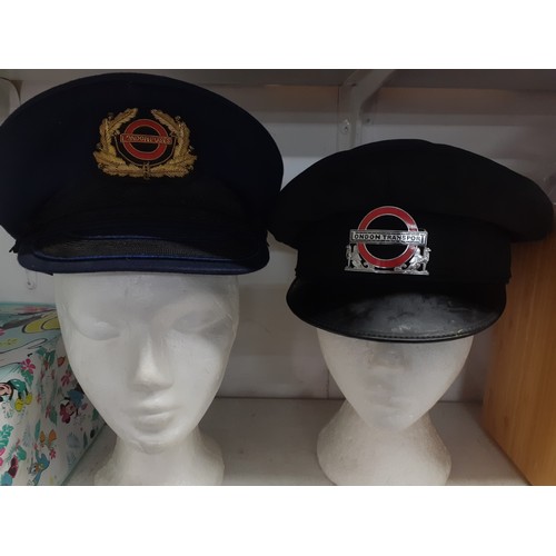 42 - A vintage London Transport peaked cap with metal hat badge, a vintage navy London Buses peaked cap w... 