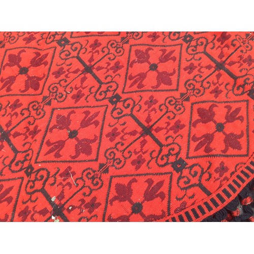 55 - A 1960's/70's Casa Pupo red and black oval woollen table covering/rug with black crotchet fringe. Lo... 