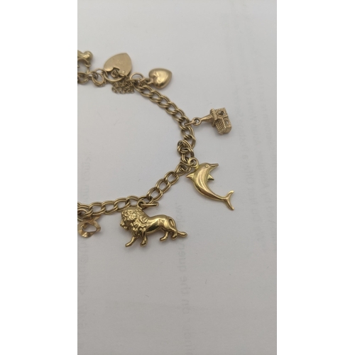 1 - A 
9ct gold charm bracelet with eight 9ct and yellow gold charms to include a lion, rabbit, penguin ... 