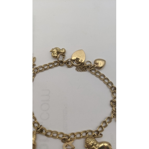 1 - A 
9ct gold charm bracelet with eight 9ct and yellow gold charms to include a lion, rabbit, penguin ... 