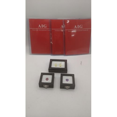 101 - Three sets of AIG gems to include 4cts oval cabochon natural red ruby, a pair of 9.72ct pear facet c... 