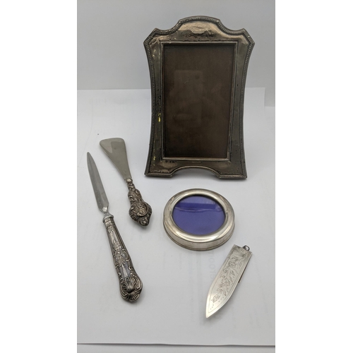 122 - Mixed silver items to include two silver photograph frames, a silver handled letter opener and shoe ... 