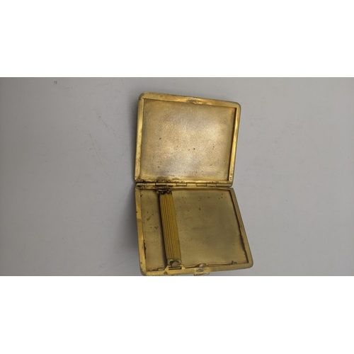 164 - A gold plated and enamel fronted cigarette case, having an engine turned back and enamel scene to th... 