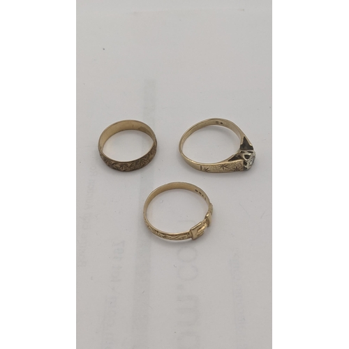 6 - Three 9ct gold rings to include a solitaire ring set with a diamond on wedding band and a buckle rin... 