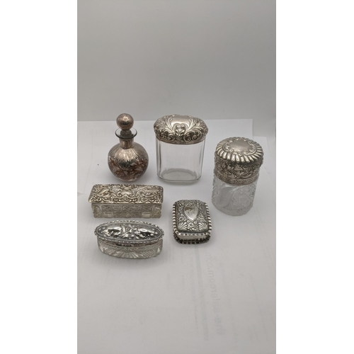 66 - Silver dressing table items to include three pots/jars, two having floral embossed lids, together wi... 