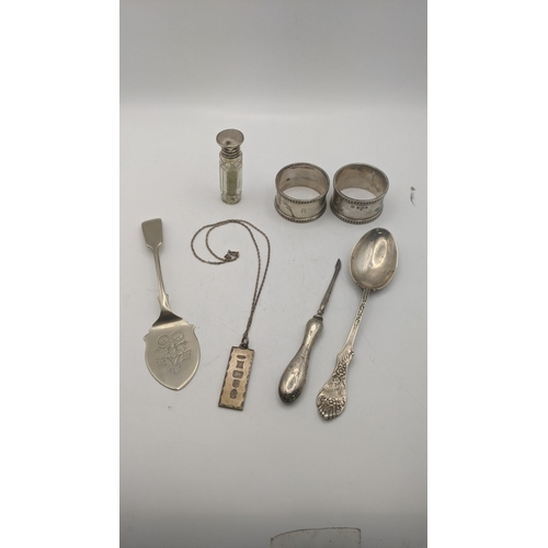 80 - Mixed silver to include a pair of napkin rings along with an ingot, a spoon with a floral terminal a... 