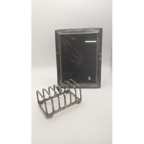 97 - Silver to include a toast rack A/F 122.g together with a silver fronted photo frame 
LocationA2T
If ... 