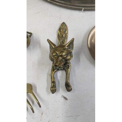 514 - A mixed lot to include a brass door knocker in the form of a fox along with other brass items, a sil... 