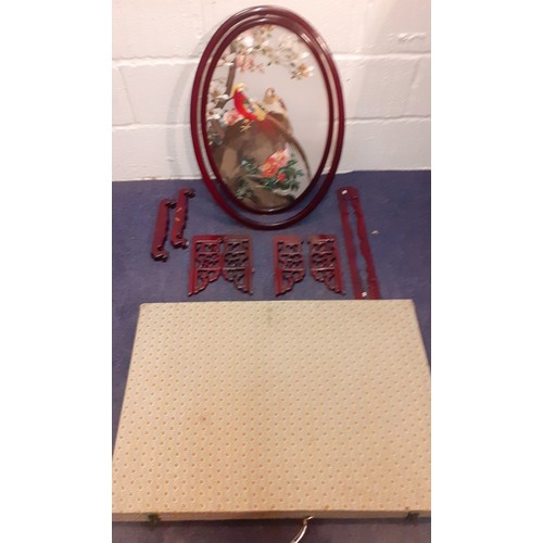 67 - An Oriental screen in oval form mounted on a red wooden frame with a silk embroidered picture amongs... 