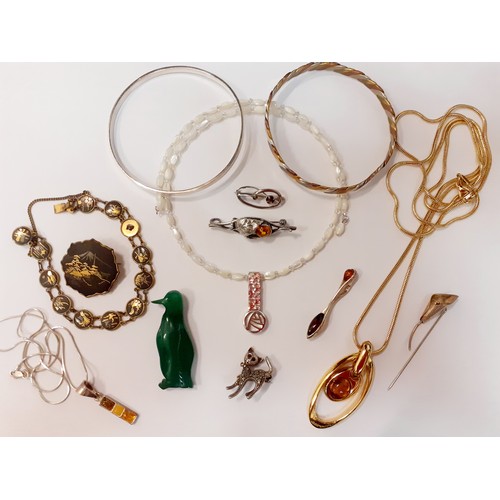 60 - A small quantity of costume jewellery to include a silver bangle stamped 800, a silver and amber pen... 