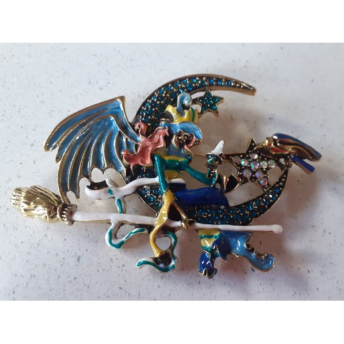 499 - A large gold tone, enamel effect and coloured crystal brooch in the form of a winged witch sat on a ... 