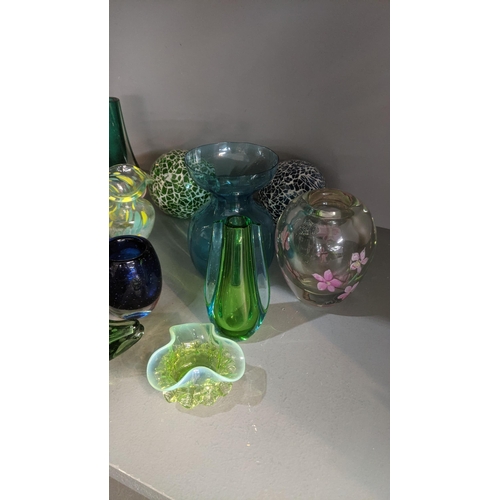 556 - A group  of art and coloured glassware to include a variety of small vases, along with one larger ex... 