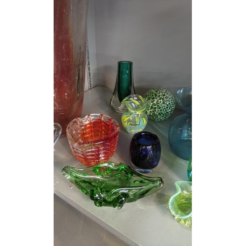 556 - A group  of art and coloured glassware to include a variety of small vases, along with one larger ex... 