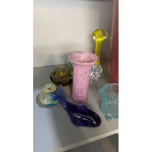 556 - A group  of art and coloured glassware to include a variety of small vases, along with one larger ex... 