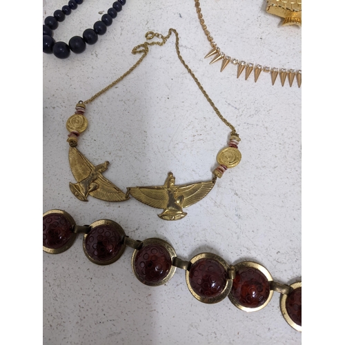 596 - A selection of vintage costume jewellery to include an opalescent and clear glass necklace, a gilt m... 