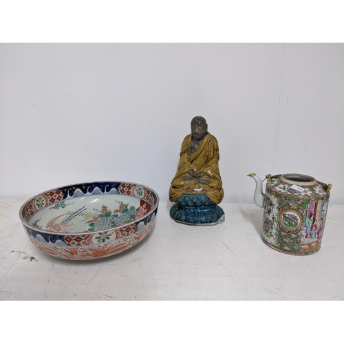 602 - THIS LOT HAS BEEN WITHDRAWN

 Chinese pottery figure of a Luohan, seated with hands clasps in a dark... 