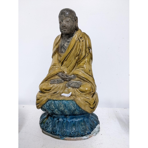 602 - THIS LOT HAS BEEN WITHDRAWN

 Chinese pottery figure of a Luohan, seated with hands clasps in a dark... 