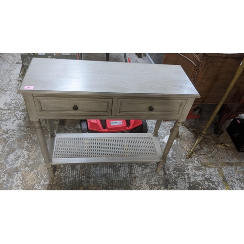 538 - A modern grey painted side table with two drawers over a caned undertier, 81 x 91 x 33cm
Location:G
... 