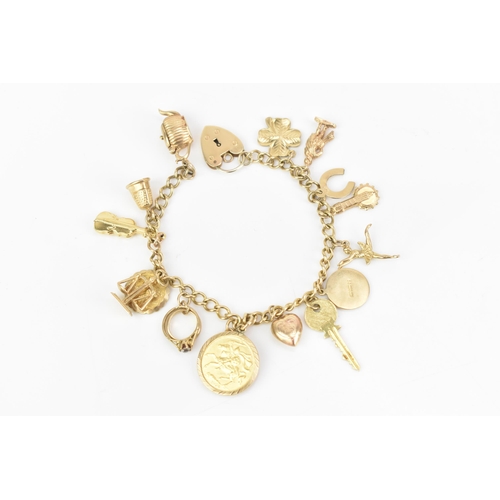 108 - A 9ct yellow gold curb link charm bracelet, with various 9ct gold charms including a thimble, teapot... 